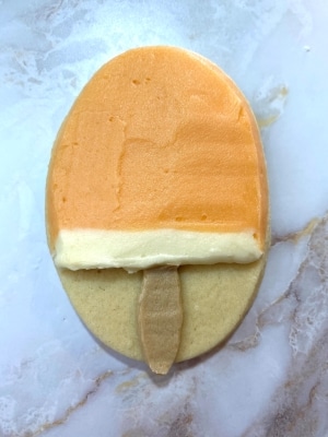 orange flavored buttercream on creamsicle cookie, edges cleaned with palette knife