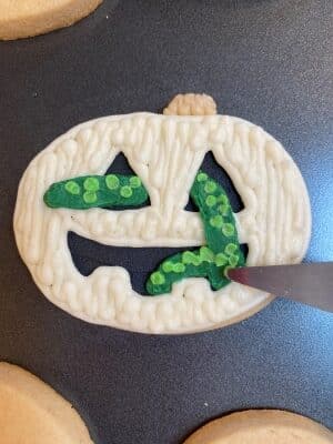 Halloween snake sugar cookies with buttercream smoothing the snake body a bit